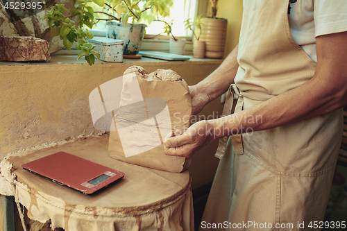 Image of Creating a jar or vase of white clay close-up. Master crock.