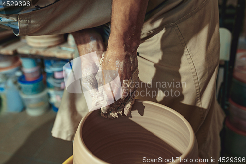 Image of Creating a jar or vase of white clay close-up. Master crock.