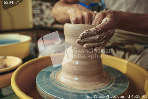 Image of Creating a jar or vase of white clay close-up. Master crock.