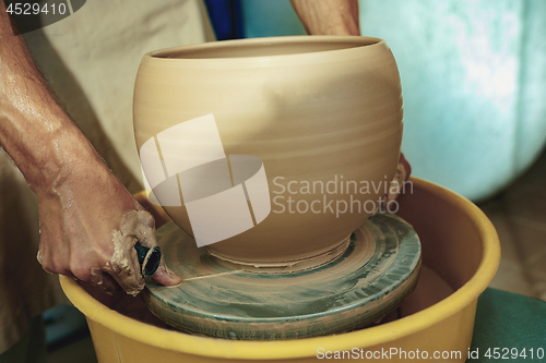 Image of Creating a jar or vase of white clay close-up. Master crock.