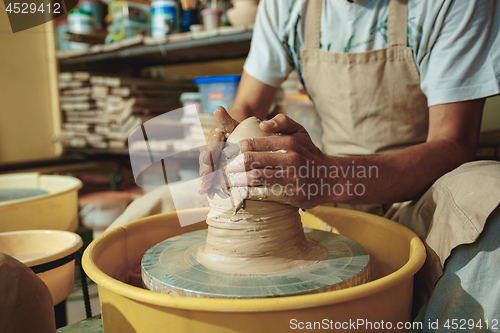 Image of Creating a jar or vase of white clay close-up. Master crock.