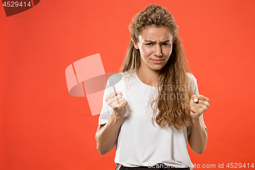 Image of Beautiful woman looking suprised and bewildered isolated on red