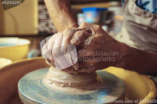 Image of Creating a jar or vase of white clay close-up. Master crock.