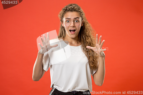 Image of Beautiful woman looking suprised isolated on orange