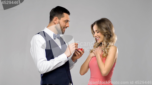 Image of happy man giving engagement ring to woman