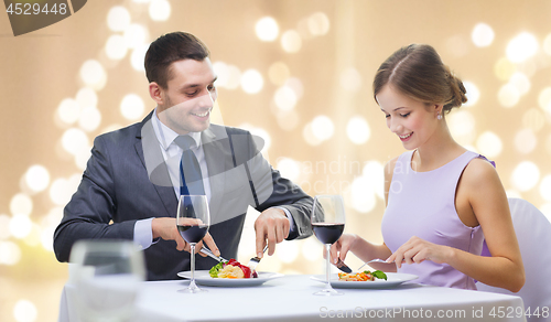 Image of smiling couple eating appetizers at restaurant