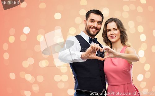 Image of happy couple making hand heart on valentines day