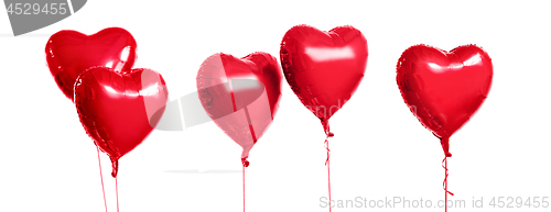 Image of five red heart shaped helium balloons on white