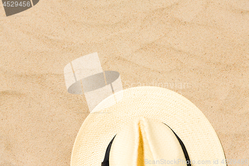 Image of straw hat on beach sand