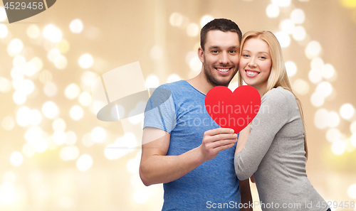 Image of happy couple with red heart over festive lights