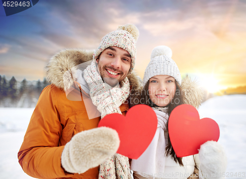 Image of happy couple with red hearts over winter nature