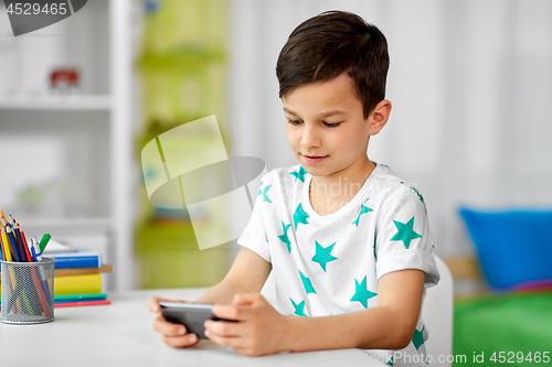 Image of happy boy with smartphone at home