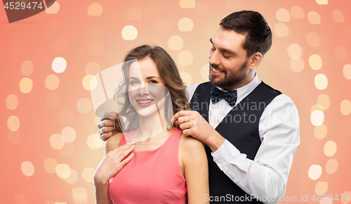 Image of happy man puts necklace on his girlfriend