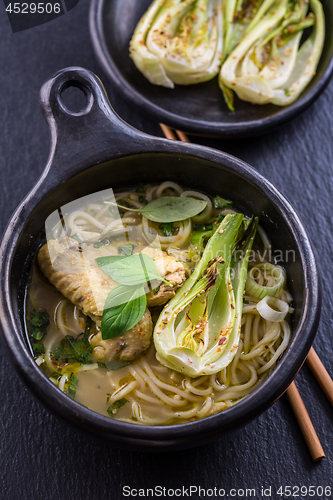 Image of Thai green curry chicken soup with pak choi