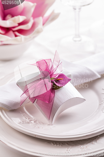 Image of Beautiful table setting with small present for the guest