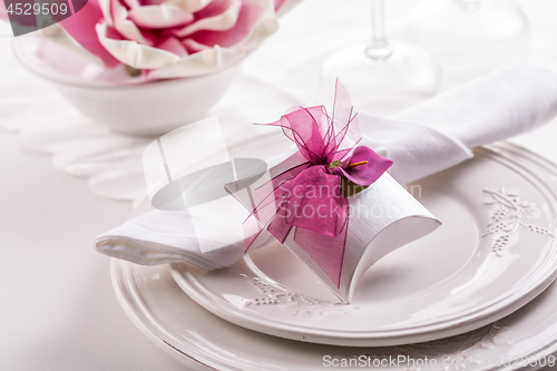 Image of Beautiful table setting with small present for the guest