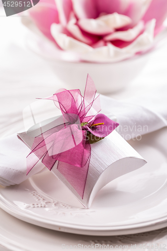 Image of Beautiful table setting with small present for the guest