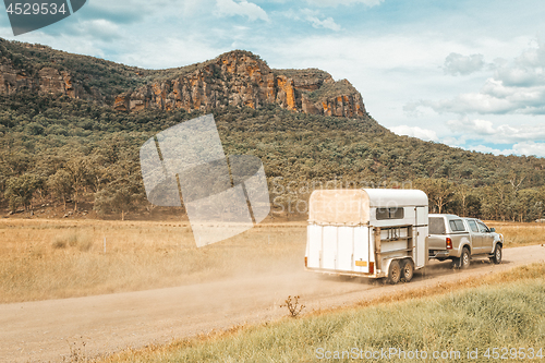 Image of Horse float pulled by four wheel drive along a dirt road in rural Australia