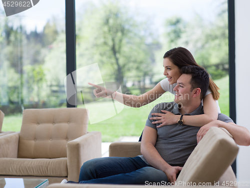 Image of young handsome couple hugging on the sofa