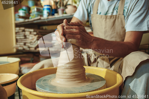 Image of Creating a jar or vase of white clay close-up. Master crock.