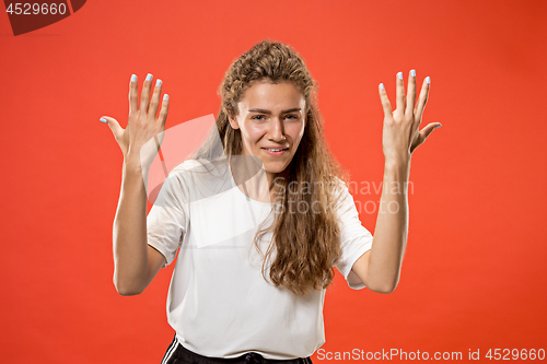 Image of Beautiful woman looking suprised and bewildered isolated on red