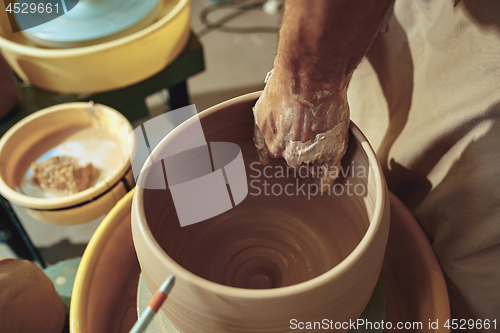 Image of Creating a jar or vase of white clay close-up. Master crock.