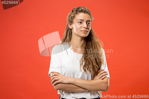 Image of The happy woman standing and smiling against red background.