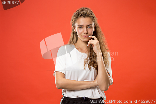 Image of The happy woman standing and smiling against red background.