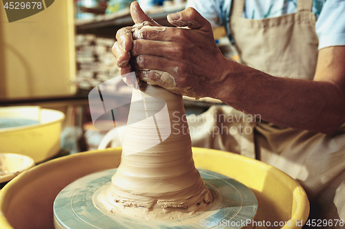 Image of Creating a jar or vase of white clay close-up. Master crock.
