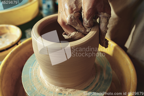 Image of Creating a jar or vase of white clay close-up. Master crock.