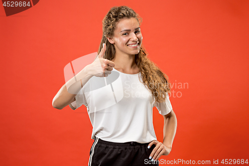 Image of The happy business woman standing and smiling against red background.