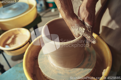 Image of Creating a jar or vase of white clay close-up. Master crock.