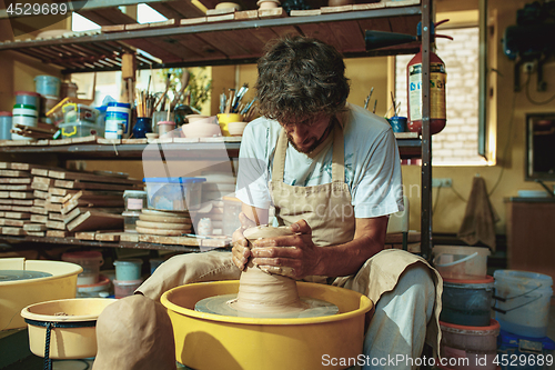 Image of Creating a jar or vase of white clay close-up. Master crock.