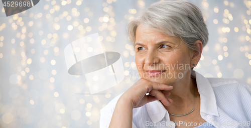 Image of portrait of senior woman over festive lights