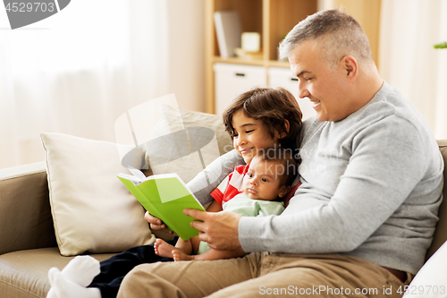 Image of happy father with sons reading book at home
