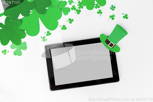 Image of tablet pc and st patricks day decorations on white