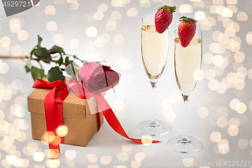 Image of two champagne glasses and gift with red rose