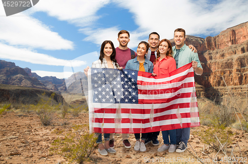 Image of friends with american flag over grand canyon