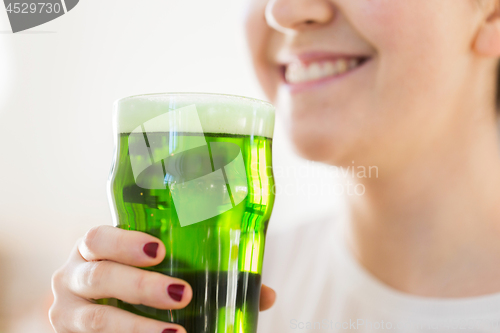 Image of close up of woman with green beer in glass