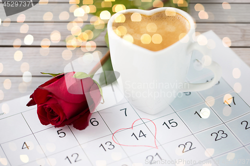 Image of close up of calendar, heart, coffee and red rose