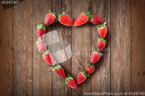 Image of heart shaped frame made of fresh strawberries