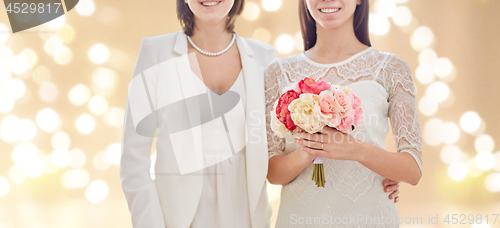 Image of close up of happy lesbian couple with flowers