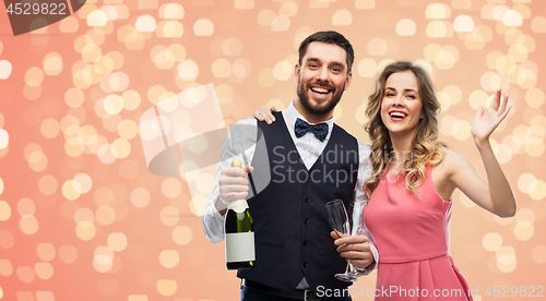 Image of happy couple with bottle of champagne and glasses