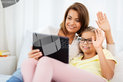 Image of happy mother and daughter with tablet pc at home