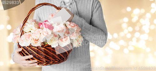 Image of man holding basket of flowers with note