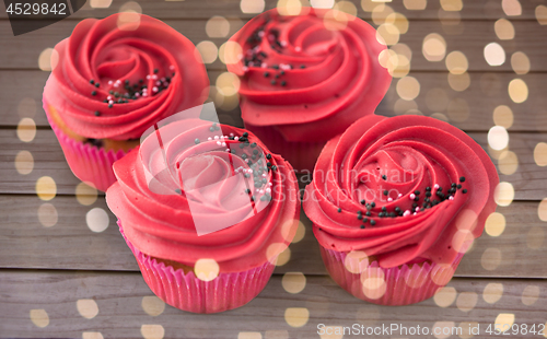 Image of close up of cupcakes with red buttercream frosting