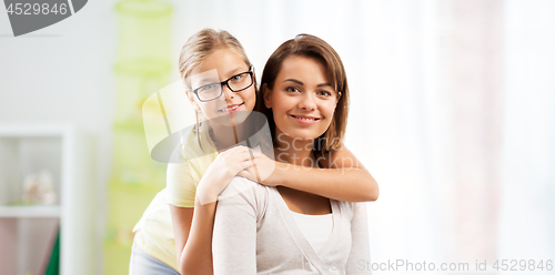 Image of portrait of happy mother and daughter at home