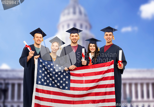 Image of graduate students with diplomas and american flag