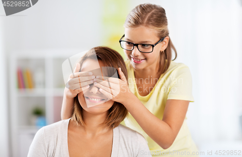 Image of happy mother and daughter playing guess who game