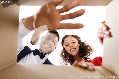 Image of happy couple opening christmas gift box